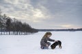 Little blonde caucasian Swedish girl playing and cuddle puppy dog in swedish winter landscape