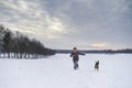 Little blonde caucasian Swedish girl running and playing with dog in winter landscape Royalty Free Stock Photo