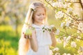 Little blonde girl in blossom apple tree garden Royalty Free Stock Photo