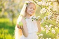 Little blonde girl in blossom apple tree garden Royalty Free Stock Photo