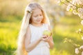 Little blonde girl in blossom apple tree garden Royalty Free Stock Photo