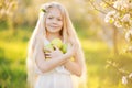 Little blonde girl in blossom apple tree garden Royalty Free Stock Photo