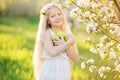 Little blonde girl in blossom garden with apples Royalty Free Stock Photo