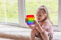 Little blonde girl children play with new trend sensory toy