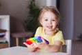 Little blonde girl children play with new trend sensory toy
