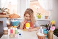 Little blonde girl coloring eggs for Easter holiday at home