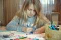 Little girl drawing on her book and having fun at playtable. Child girl does her school homework at home Royalty Free Stock Photo