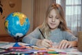 Little girl drawing on her book and having fun at playtable. Child girl does her school homework at home Royalty Free Stock Photo