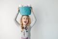 Little blonde girl holding basket with painted eggs. Easter day.