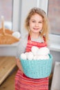 Little blonde girl holding basket with painted eggs. Easter day. Royalty Free Stock Photo