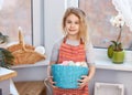 Little blonde girl holding basket with painted eggs. Easter day. Royalty Free Stock Photo