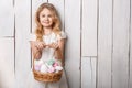 Little blonde girl holding basket with painted eggs. Easter day. Royalty Free Stock Photo