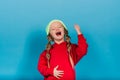 Little blonde girl, she laughing, sitting on floor, posing isolated on blue. Childhood, fashion Royalty Free Stock Photo