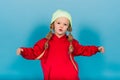 Little blonde girl, she laughing, sitting on floor, posing isolated on blue. Childhood, fashion Royalty Free Stock Photo