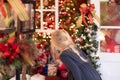 Little blonde girl looking at holiday lights and decorations Royalty Free Stock Photo