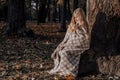 Little blonde girl in a plaid whip in the park in autumn Royalty Free Stock Photo