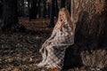 Little blonde girl in a plaid whip in the park in autumn Royalty Free Stock Photo