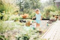 Little blonde girl playing at garden with water in a tin basin. Kids gardening. Summer outdoor water fun. Childhood in the country Royalty Free Stock Photo