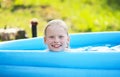 Little blonde girl in outdoor swimming pool on hot summer day. Royalty Free Stock Photo