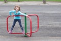 Little blonde girl playing on small merry go round