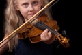 Little blonde girl playing violin isolated on a black background Royalty Free Stock Photo