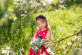 Little blonde girl in a red dress reads a book with fairy tales in nature Royalty Free Stock Photo