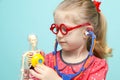 Little blonde girl with red glasses listen heart with stethoscope. Royalty Free Stock Photo