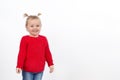 A little blonde girl in a red sweater and blue jeans. Isolate on a white background Royalty Free Stock Photo