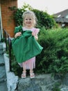 A little blonde girl smiles while holding a gift in her hands. Gift wrapping. Royalty Free Stock Photo