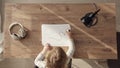 little blonde girl starts drawing with black marker, top down view of child at work desk at home or in kindergarten. Kid Royalty Free Stock Photo