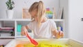 Little blonde girl with two ponytales play with magic sand. Development of fine motor skills, early education, sensorics