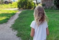 Little blonde six years old walks along the path in the park, a portrait of a preschooler, a girl with blond hair, a photo from th