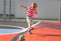 Little blonde smiling boy playing soccer on the playground - hitting back the ball Royalty Free Stock Photo