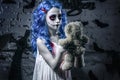 Little blue hair girl in bloody dress with scary halloween makeup with teddy bear Royalty Free Stock Photo