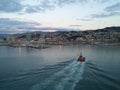 Little boat accompanies the cruise ship in the port