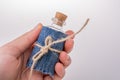 Little bottle covered with canvas in hand