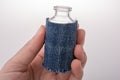 Little bottle covered with canvas in hand