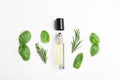 Little bottle of essential oil with different herbs on white background Royalty Free Stock Photo