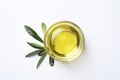 Little bowl with olive oil and leaves on white background