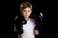 Little boxer portrait in black boxing gloves in closed position