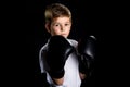 Little boxer portrait in black boxing gloves in defensive position