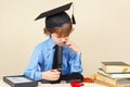 Little boy in academic hat funny thought, seeing something in microscope