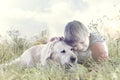 Little boy affectionately hugs his dog in the middle of nature