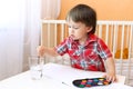 Little boy age of 22 months with paints Royalty Free Stock Photo