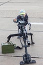 A little boy aims at a large-caliber military machine gun