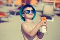 Little boy applying sunscreen spray vintage