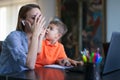 Little boy asking tired mother at home office during online job Royalty Free Stock Photo