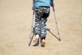 A little boy with Autism, Asperger syndrome on crutches after breaking his leg walks on the beach.