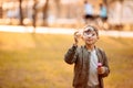 Little boy in an autumn jacket playing with soap bubbles Royalty Free Stock Photo