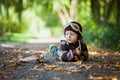 Little boy with aviator hat, lying on the ground in a park Royalty Free Stock Photo